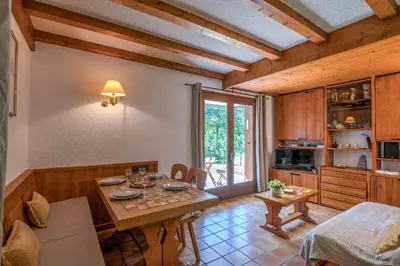 a kitchen with a table and a dining room at Appartement Pruniers - Welkeys in Megève