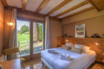 a bedroom with a large bed and a large window at Appartement Pruniers - Welkeys in Megève