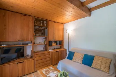 a living room with a couch and a tv at Appartement Pruniers - Welkeys in Megève