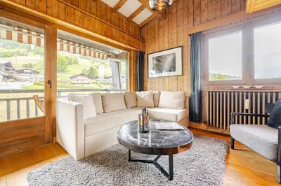a living room with a white couch and a coffee table at Appartement familial et cosy 3 chambres in Megève