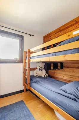 a kitchen with wooden cabinets and tiles on the wall at Appartement familial et cosy 3 chambres in Megève
