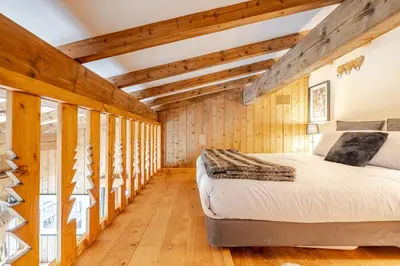 a bedroom with a large white bed with two pillows at Appartement familial et cosy 3 chambres in Megève