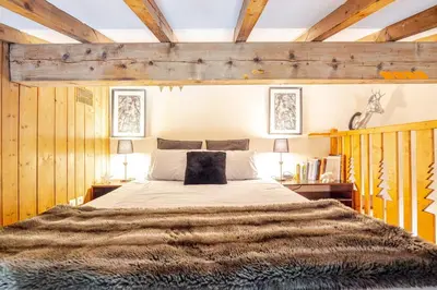 two beds in a room with a mirror at Appartement familial et cosy 3 chambres in Megève