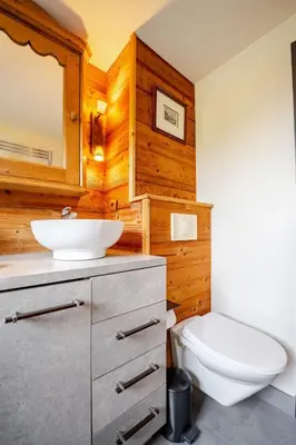 a bedroom with a large bed and wooden ceilings at Appartement familial et cosy 3 chambres in Megève