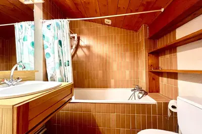 a bathroom with a tub and a sink and a toilet at Le Grenier du Feug in Combloux