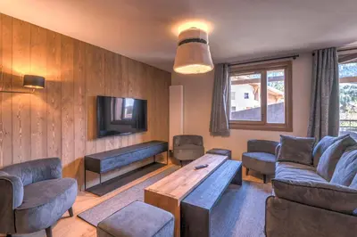a living room with a couch and a tv at Appartement Havre des Alpes - Welkeys in Megève