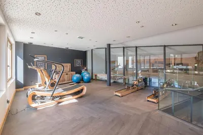 a gym with a treadmill and a table and glass at Appartement Havre des Alpes - Welkeys in Megève
