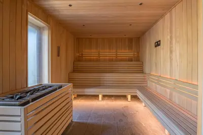 an empty sauna with a stove and a window at Appartement Havre des Alpes - Welkeys in Megève