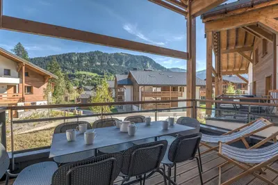 a table and chairs on a balcony with a view at Appartement Havre des Alpes - Welkeys in Megève