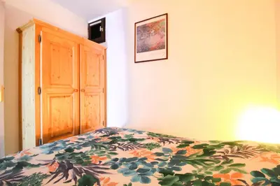 a bedroom with a bed with a floral comforter at Studio cabine lumineux et calme, au centre de Flaine Foret in Flaine