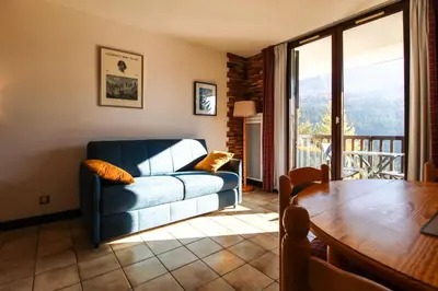a living room with a couch and a table at Studio cabine lumineux et calme, au centre de Flaine Foret in Flaine