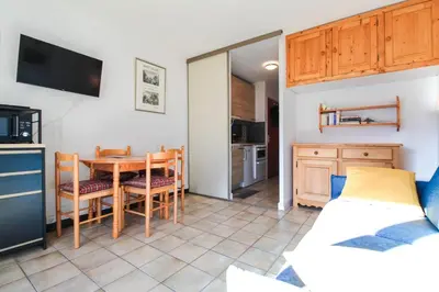 a kitchen and dining room with a table and chairs at Studio cabine lumineux et calme, au centre de Flaine Foret in Flaine
