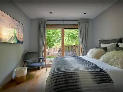 a bedroom with a large bed and a window at Chalet RevAlp - OVO Network in Combloux