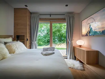 a bedroom with a large bed with a large window at Chalet RevAlp - OVO Network in Combloux