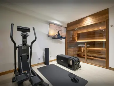 a room with a gym with a treadmill and a television at Chalet RevAlp - OVO Network in Combloux