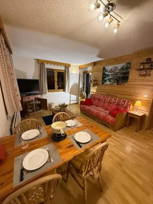 a living room with a table and chairs and a couch at Appartement Samoens Cosy in Samoëns