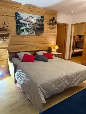 a bedroom with a large bed with red pillows at Appartement Samoens Cosy in Samoëns