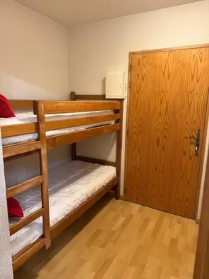 a room with two bunk beds and a door at Appartement Samoens Cosy in Samoëns