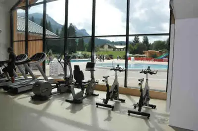 a gym with cardio equipment and a swimming pool at gîte 6 pers RC domaine skiable Grand Massif les Carroz Flaine Morillon Samoens in Les Carroz d'Araches