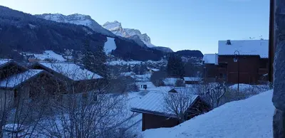 a town with snow covered roofs and a mountain at gîte 6 pers RC domaine skiable Grand Massif les Carroz Flaine Morillon Samoens in Les Carroz d'Araches
