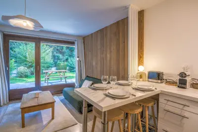 a living room with a table and a kitchen at Appartement Rosset - Welkeys in Megève