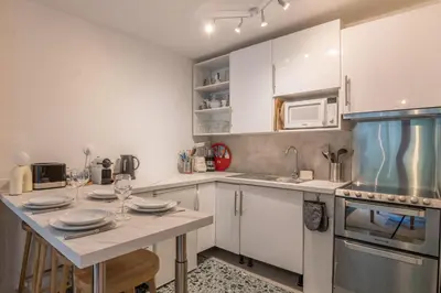 a kitchen with white cabinets and a table with plates at Appartement Rosset - Welkeys in Megève