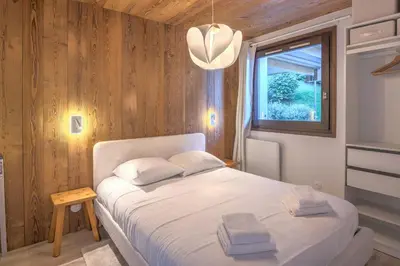 a bedroom with a white bed and a window at Appartement Rosset - Welkeys in Megève