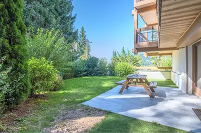 a picnic table in a yard next to a house at Appartement Rosset - Welkeys in Megève