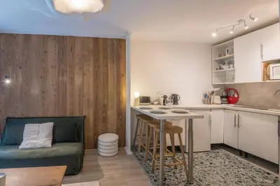 a kitchen with a couch and a table in a room at Appartement Rosset - Welkeys in Megève