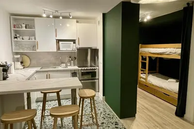 a kitchen with a table and chairs and a bunk bed at Appartement Rosset - Welkeys in Megève