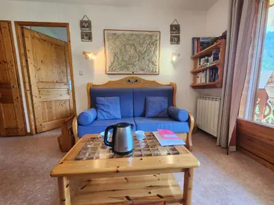 a living room with a blue couch and a coffee table at T3 calme à Samoëns, proche centre, WIFI, parking privé - FR-1-629-150 in Samoëns