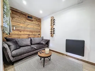 a living room with a couch and a tv at Modern 2BR Apt with Mountain Views & Private Parking in Les Houches