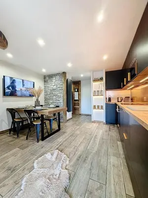 a kitchen and dining room with a table and a counter at Modern 2BR Apt with Mountain Views & Private Parking in Les Houches