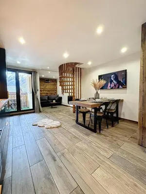 a living room with a table and a dining room at Modern 2BR Apt with Mountain Views & Private Parking in Les Houches