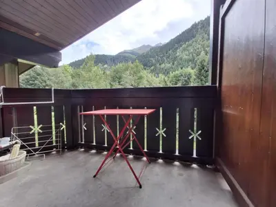 a red table in a room with a large window at Les Contamines Montjoie in Le Cugnon