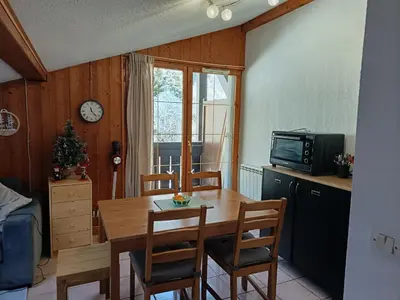a kitchen with a table and chairs and a television at Les Contamines Montjoie in Le Cugnon