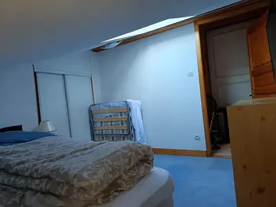a bedroom with a bed and a sliding glass door at Les Contamines Montjoie in Le Cugnon