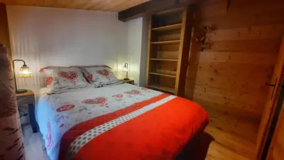 a bedroom with a bed with a red and white comforter at NEW - Le Splendid' - Duplex standing rénové 6-8 pers in Arâches-la-Frasse