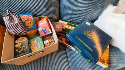 a box full of books sitting on a couch at NEW - Le Splendid' - Duplex standing rénové 6-8 pers in Arâches-la-Frasse