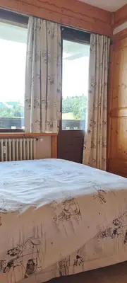 a bedroom with a bed and two windows at AP-37 La Grande Cordée Combloux in Combloux