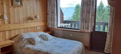a bedroom with a bed and a large window at AP-37 La Grande Cordée Combloux in Combloux