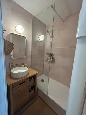 a bathroom with a sink and a glass shower at Petit appartement cosy in Les Contamines-Montjoie