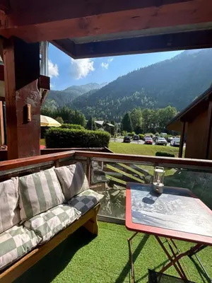 a balcony with a couch and a table and a view at Petit appartement cosy in Les Contamines-Montjoie