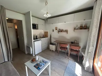a living room with a table and a kitchen at Petit appartement cosy in Les Contamines-Montjoie