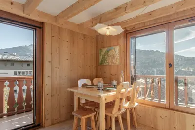 a dining room with a table and chairs and a balcony at Le Mont Joux - Vue montagne in Saint-Gervais-les-Bains