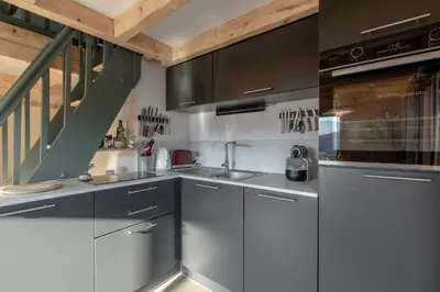 a kitchen with stainless steel cabinets and a staircase at Le Mont Joux - Vue montagne in Saint-Gervais-les-Bains