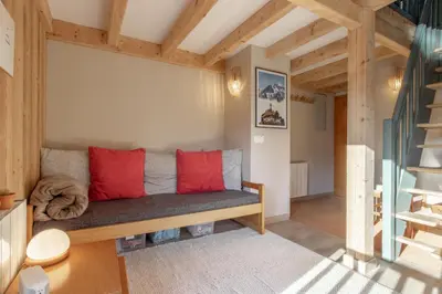 a living room with a couch with red pillows at Le Mont Joux - Vue montagne in Saint-Gervais-les-Bains