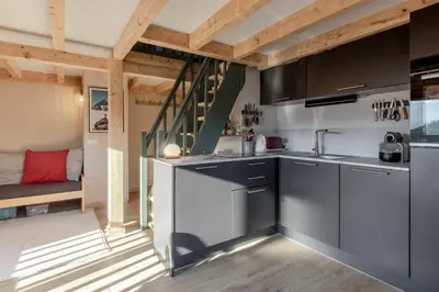 a kitchen with stainless steel appliances in a tiny house at Le Mont Joux - Vue montagne in Saint-Gervais-les-Bains