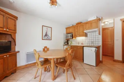 a kitchen with a wooden table and chairs at Tete Rousse - Ski aux pieds - Piscine - Terrace in Les Houches