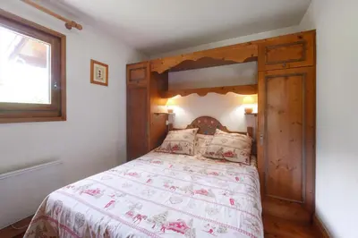 a bedroom with a wooden bed with a wooden headboard at Tete Rousse - Ski aux pieds - Piscine - Terrace in Les Houches